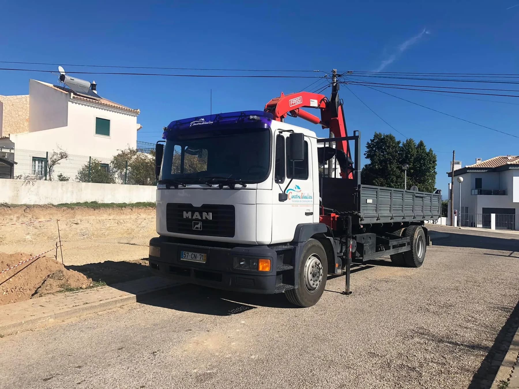 Camião grua da Construidealiza estacionado junto a um lote preparado para obra